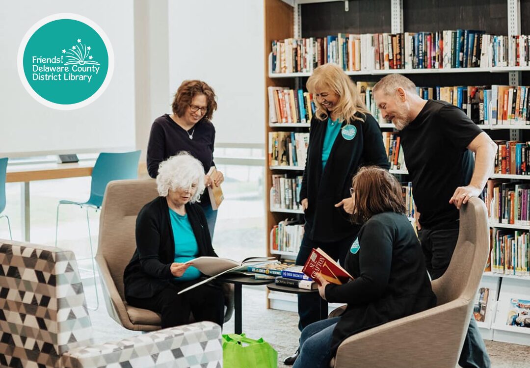 Five members of the Friends of the DCDL are seen at Liberty Library browsing books.