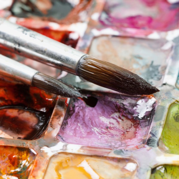 Color Theory & Mixing. A palette of paints with two brushes.