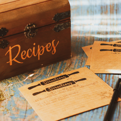 A wooden recipe box with yellowed recipe cards.